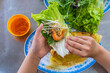 Human eating Banh Xeo crepe with vegetables- Vietnamese cuisine
