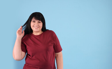 Poster - Beautiful overweight mature woman with charming smile on turquoise background. Space for text