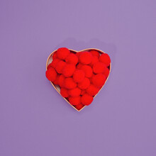 Love Concept. Paper Heart Shape Box With Little Fluffy Red Balls On Purple Pastel Background. Valentine Day. Flat Lay.
