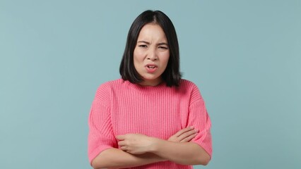 Wall Mural - Displeased irritated sad angry young woman of Asian ethnicity 20s wears pink shirt closed eyes cover ears do not want to listen scream isolated on plain pastel light blue background studio portrait
