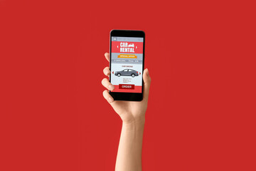 Woman holding mobile phone with open car rent app on red background