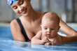 © Pixel-Shot - Adorable little baby with coach in swimming pool, closeup