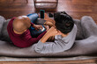 © Vergani Fotografia - brazilian gay couple looking at mobile screen in the sofa
