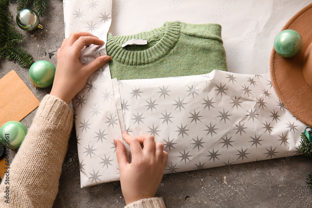 Woman making stylish Christmas gift on table