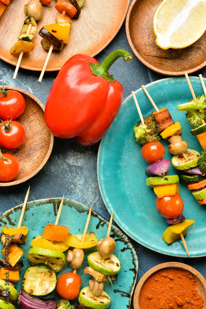Composition with tasty vegetable skewers and lemon on blue background