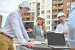 © zinkevych - Elegant building supervisor talking to builders outside