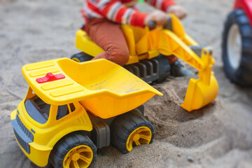 Children playing in the sandbox sandpit, kids with toy car vehicle, playground in kindergarten day care