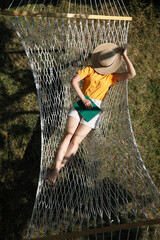 Wall Mural - Young woman resting in hammock outdoors on sunny day, above view