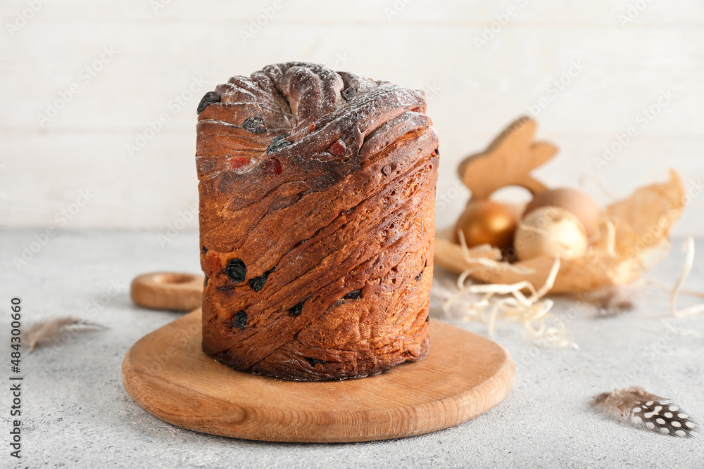 Wooden board with delicious Easter cake on table