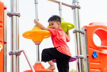 Asian Child Playing On Outdoor Playground, Happy Preschool Little Kid Having Funny While Playing On The Playground Equipment In The Daytime In Summer, Outside Education, Little Boy Climbing
