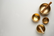 Golden Singing Bowls And Mallets On White Background, Flat Lay. Space For Text