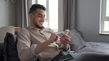 Young man using phone and internet technology sitting on sofa rest at home