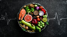 Food Banner. Healthy Foods Low In Carbohydrates. Food For Heart Health: Salmon, Avocados, Blueberries, Broccoli, Nuts And Mushrooms. On A Black Stone Background. Top View.