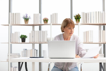 Wall Mural - senior woman using laptop computer and serious at work