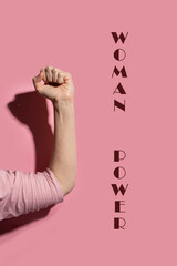 Wall Mural - Woman flexing biceps on pink background with hard shadow. Woman power concept.