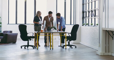 Lets talk it over. Full length shot of a group of designers working together in their creative office.