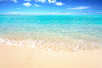 Wall Mural - beautiful sandy beach with white sand and rolling calm wave of turquoise ocean on sunny day. white c