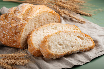 Freshly baked sliced loaf of creamy bread on napkin 