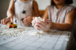 © natalialeb - Funny children play with artificial snow at home in the kitchen. Educational classes and experiments with children at home. Sensory development and games at home. Snow from starch and shaving foam