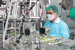 © feeling lucky - Worker in personal protective equipment or PPE inspecting quality of mask and medical face mask production line in factory, manufacturing industry and factory concept.