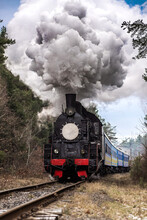 Retro Steam-powered Train Goes On Rails Through The Woods And Emits Steam