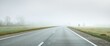 Panoramic view from the car of the empty highway through the fields and forest in a fog at sunrise. Europe. Transportation, logistics, travel, road trip, freedom, driving. Rural scene