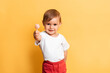 © Anastasia - A little girl is eating a sweet lollipop on a stick. Yellow background. The concept of prevention of caries and diabetes in children.