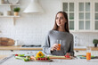 © BestForYou - Portrait of a beautiful healthy woman with orange juice in the kitchen while preparing a vegetarian breakfast.