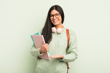 Wall Mural - young pretty hispanic woman smiling cheerfully, feeling happy and showing a concept. student concept