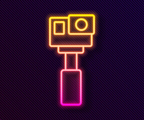 Poster - Glowing neon line Action extreme camera icon isolated on black background. Video camera equipment for filming extreme sports. Vector