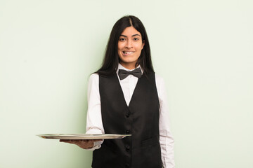 Wall Mural - young pretty hispanic woman looking puzzled and confused. waiter with tray concept