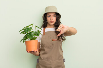 Canvas Print - young pretty hispanic woman feeling cross,showing thumbs down. farmer or gardener concept