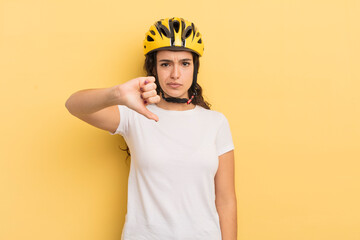 Canvas Print - young pretty hispanic woman feeling cross,showing thumbs down. bycicle concept