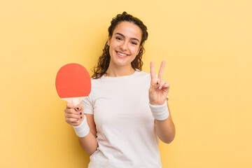 Wall Mural - young pretty hispanic woman smiling and looking friendly, showing number two. ping pong concept