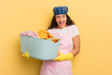 Wall Mural - young pretty hispanic woman laughing out loud at some hilarious joke. wash and clothes concept