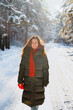 © KseniaJoyg - Beautiful young woman in a long down jacket in a snowy forest in winter on a sunny day