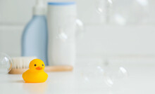 Baby Bath Accessories. Child Care. Miniature Yellow Rubber Duckling For Bathing With A Brush And Shampoo Bottles. Soap Bubbles, Bath Foam.