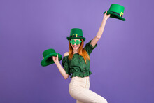 Photo Of Cute Pretty Young Lady Wear Green Blouse Cap Celebrating St Patrick Day Holding Headwears Isolated Purple Color Background