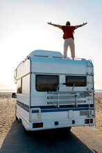 Man Enjoying Freedom On Traveling Van In Sunset