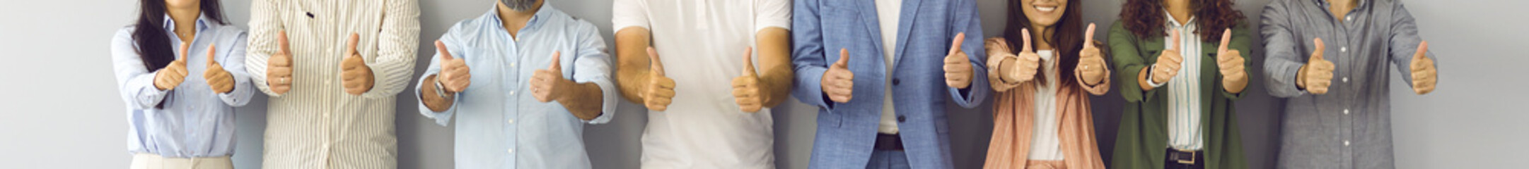 Happy business team doing thumbs up all together. Banner background with midsection shot of group of successful young and mature people in office suits standing in row, giving thumbs up and smiling