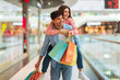 © Prostock-studio - Couple Having Fun Shopping, Man Carrying Woman Piggyback In Mall