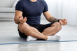 © Prostock-studio - Unrecognizable millennial muscular european male athlete sitting on floor on mat in lotus position and practicing yoga