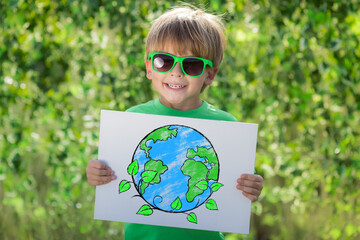 Canvas Print - Happy child showing recycle sign outdoor in spring park