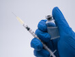 Hand close up holding syringe and vaccine bottle