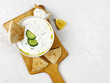 Traditional greek sauce tzatziki in a white bowl on a wooden desk on concrete grey background