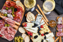 Food Antipasto Prosciutto Ham, Salami, Olives And Grissini Bread Sticks. Cheese On A Board Parmesan, Pecorino, Gorgonzola. Charcuterie Board. Two Glasses Of White Wine Or Prosecco