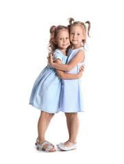 Poster - Adorable little sisters hugging on white background