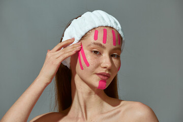 Face lifting tapes. Young girl stick anti wrinkles patches strips on cheeks for tightening skin. Rejuvenation treatment