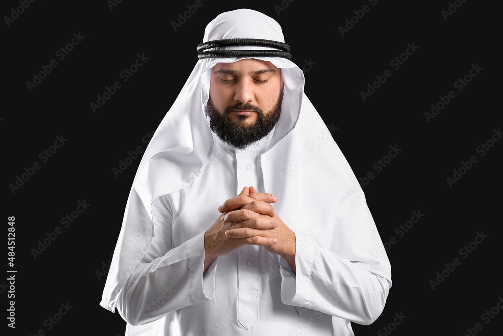 Muslim man praying on black background