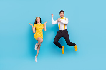 Full length portrait of excited active partners raise hands fists flight isolated on blue color background